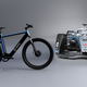 A photo of the Mercedes Formula E car next to an N+ electric bike.